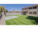 Low-maintenance backyard features artificial turf, a stone patio, block fence, and a covered patio area at 763 E Maddison St, San Tan Valley, AZ 85140