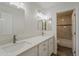 The renovated bathroom boasts a modern double vanity, white cabinets, and a tiled shower at 763 E Maddison St, San Tan Valley, AZ 85140