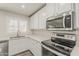 Well-lit kitchen featuring stainless steel appliances, white cabinets, countertops, and modern fixtures at 763 E Maddison St, San Tan Valley, AZ 85140