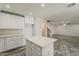 Open-concept kitchen with an island, white cabinets, and views to an adjacent living area at 763 E Maddison St, San Tan Valley, AZ 85140