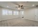 Large main bedroom featuring plush carpeting, a ceiling fan, ample natural light, and views to two bathrooms at 763 E Maddison St, San Tan Valley, AZ 85140