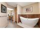 Luxurious bathroom featuring soaking tub with marble accent wall, and double vanity in the background at 7673 N Via De Platina Dr, Scottsdale, AZ 85258
