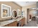 Elegant bathroom featuring double sinks, granite countertops, and modern, lighted mirrors at 7673 N Via De Platina Dr, Scottsdale, AZ 85258