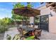 Outdoor patio area with dining table, chairs, umbrella, and lush landscaping for relaxing and entertaining at 7673 N Via De Platina Dr, Scottsdale, AZ 85258