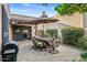 Cozy patio with outdoor dining set, grill, and view of the landscaped backyard at 7673 N Via De Platina Dr, Scottsdale, AZ 85258