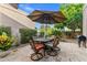 Relaxing patio area with outdoor dining set, umbrella, and lush landscaping at 7673 N Via De Platina Dr, Scottsdale, AZ 85258