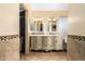 This bathroom has an antique vanity with and sinks, framed mirrors, and a walk-in closet at 7749 W Hearn Rd, Peoria, AZ 85381