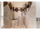Elegant bathroom featuring a tiled shower with a built-in seat, stylish fixtures, and decorative tile accents at 7749 W Hearn Rd, Peoria, AZ 85381