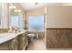 This lovely bathroom features an ornate vanity with framed mirror, decorative window, and tiled walk-in shower at 7749 W Hearn Rd, Peoria, AZ 85381