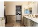 A classic bathroom boasts double vanities, tile flooring, and a walk-in closet with shelving at 7749 W Hearn Rd, Peoria, AZ 85381