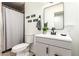 Bright bathroom features a shower with a gray curtain, gray cabinets, and modern fixtures at 7749 W Hearn Rd, Peoria, AZ 85381