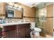 Elegant bathroom with a tiled shower, granite countertop, and dark wood cabinets at 7749 W Hearn Rd, Peoria, AZ 85381