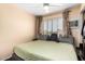 This bedroom features neutral tones, a ceiling fan, and a large window providing natural light at 7749 W Hearn Rd, Peoria, AZ 85381