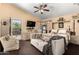 Inviting bedroom with a cozy couch, ceiling fan, dresser, and an ensuite door leading to the backyard at 7749 W Hearn Rd, Peoria, AZ 85381