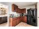 Traditional kitchen with wooden cabinets, a black refrigerator, and tiled floors at 7749 W Hearn Rd, Peoria, AZ 85381