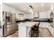 Modern kitchen with white cabinets, stainless steel appliances, an island, and bar stool seating at 7749 W Hearn Rd, Peoria, AZ 85381