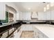 Stylish kitchen showcasing a stainless steel sink, mosaic backsplash, white cabinets, and black granite counters at 7749 W Hearn Rd, Peoria, AZ 85381