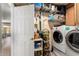 Well-organized laundry room with shelving, storage, and modern washer and dryer units at 7749 W Hearn Rd, Peoria, AZ 85381