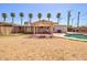 Expansive backyard featuring a refreshing pool, covered patio, and lush palm trees at 809 N Gilbert Ave, Casa Grande, AZ 85122