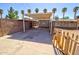 View of the backyard with covered patio and palm trees around the perimeter at 809 N Gilbert Ave, Casa Grande, AZ 85122