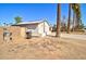Side view of the home with a block wall and desert landscaping including palm trees at 809 N Gilbert Ave, Casa Grande, AZ 85122