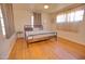 Sunny bedroom with hardwood floors, a metal bed frame, and bright natural light at 809 N Gilbert Ave, Casa Grande, AZ 85122
