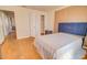 Bright bedroom with hardwood floors features a blue upholstered headboard and adjacent closet at 809 N Gilbert Ave, Casa Grande, AZ 85122