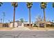 Front exterior of a home featuring palm trees, a red door, and desert landscaping at 809 N Gilbert Ave, Casa Grande, AZ 85122