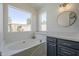 Bathroom features a tub with a ledge for storage, a vanity, and a large window at 8370 W Audrey Ln, Peoria, AZ 85382