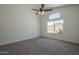 Bright bedroom featuring a ceiling fan and a large window that brings in natural light at 8370 W Audrey Ln, Peoria, AZ 85382