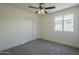 A bright bedroom features carpet, a ceiling fan, and a window at 8370 W Audrey Ln, Peoria, AZ 85382