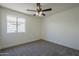 Bright bedroom with carpet, window, and ceiling fan at 8370 W Audrey Ln, Peoria, AZ 85382