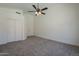 Spacious bedroom showcasing neutral carpeting, a ceiling fan, and closet space at 8370 W Audrey Ln, Peoria, AZ 85382