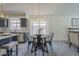 Bright dining area features a round table beneath a modern chandelier, with gray wood-look flooring at 8370 W Audrey Ln, Peoria, AZ 85382