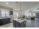 Modern open-concept kitchen with island, stylish pendant lights, and stainless steel appliances at 8370 W Audrey Ln, Peoria, AZ 85382