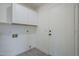 A clean laundry room with upper cabinets and tile flooring at 8370 W Audrey Ln, Peoria, AZ 85382