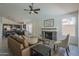 Open-concept living area with a fireplace, comfortable sofa, and a dining area in the background at 8370 W Audrey Ln, Peoria, AZ 85382