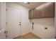 This laundry room has wood-look flooring and overhead cabinets at 866 W Geronimo St, Chandler, AZ 85225