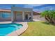 Inviting outdoor space with a covered patio, green lawn, and a refreshing pool at 866 W Geronimo St, Chandler, AZ 85225