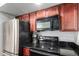 Close up of the kitchen appliances with dark granite countertops and wooden cabinets at 8787 E Mountain View Rd # 1087, Scottsdale, AZ 85258