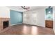 Bright living room featuring wood flooring, ceiling fan, blue accent wall and fireplace at 8787 E Mountain View Rd # 1087, Scottsdale, AZ 85258