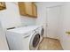 Functional laundry area with a washer, dryer, and overhead cabinets for storage at 884 W 15Th Ave, Apache Junction, AZ 85120