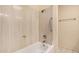 Bathroom with white tile walls, a white bathtub, and a chrome showerhead and grab bar at 927 E Charleston Ave, Phoenix, AZ 85022