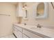 Bright bathroom with double sinks, white cabinets, white countertops, and basketweave vanity mirrors at 927 E Charleston Ave, Phoenix, AZ 85022