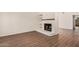 Spacious living room featuring wood-look floors and a classic white-painted brick fireplace at 927 E Charleston Ave, Phoenix, AZ 85022