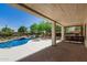 Outdoor living space featuring covered patio, pool, mature landscaping, and a bar area at 9661 E Glencove Cir, Mesa, AZ 85207