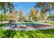 Outdoor basketball court surrounded by grassy area and mature trees and benches at 9661 E Glencove Cir, Mesa, AZ 85207