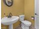 Clean half bathroom featuring a white pedestal sink and toilet at 9661 E Glencove Cir, Mesa, AZ 85207