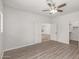 Well-lit bedroom featuring wood-look floors, double doors, and access to a walk-in closet for ample storage at 9661 E Glencove Cir, Mesa, AZ 85207