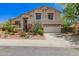 Two-story home boasts desert landscaping, a neutral color palette, and a three-car garage at 9661 E Glencove Cir, Mesa, AZ 85207